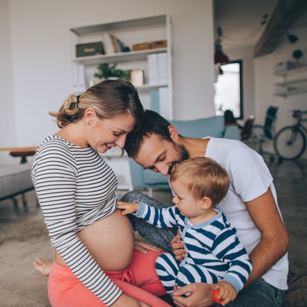 Little boy touching mums baby bump